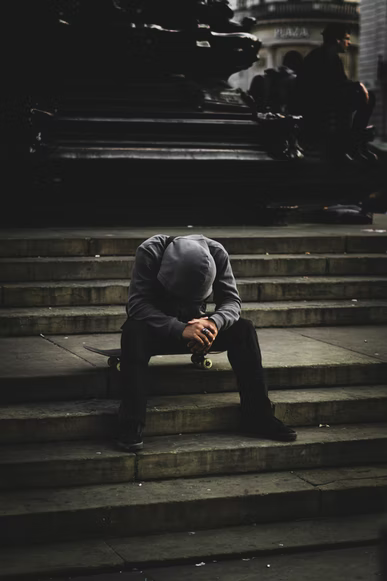 individual sitting on steps with head down individual sitting on steps with head down