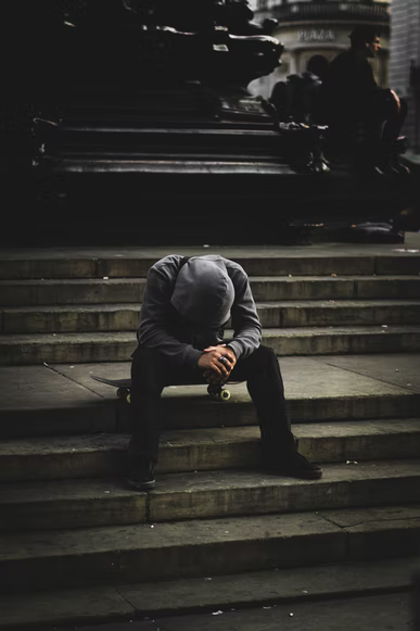 individual sitting on steps with head down