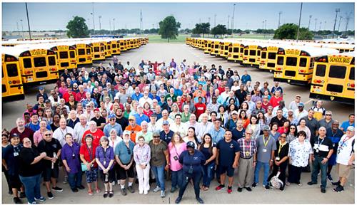 large group of transportation employees with many parked buses 