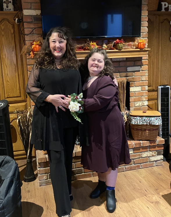 Brunette mother and daughter in front of a fireplace.