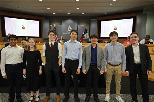 seven individuals standing in front of the board of trustees