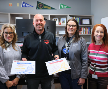 four individuals smiling with certificates