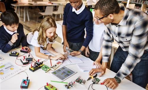 Students and teacher working on electronics 